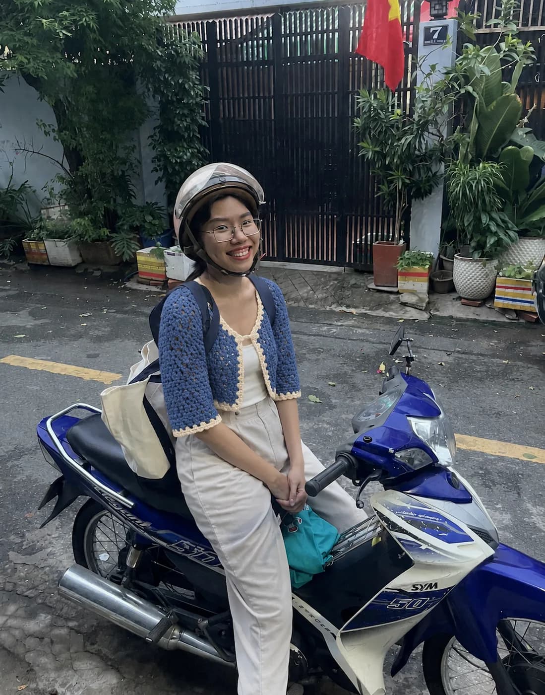 Aegean blue ribbed knit cardigan beside a vintage scooter