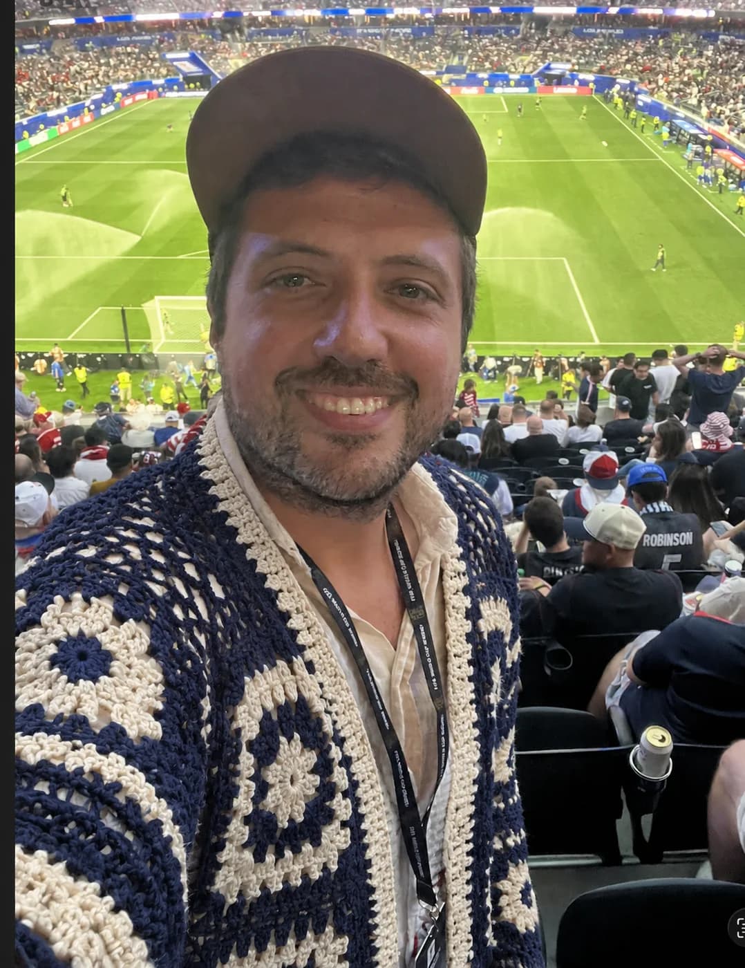Navy and cream hand-knit cardigan in stadium lighting