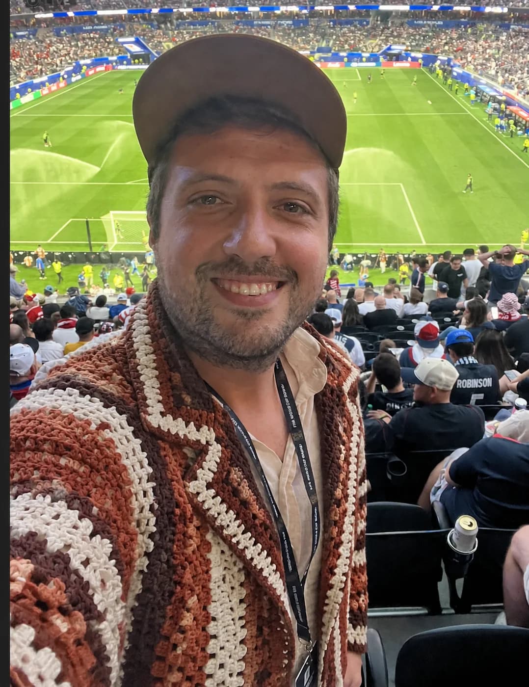 Terracotta crochet wrap jacket at an evening stadium