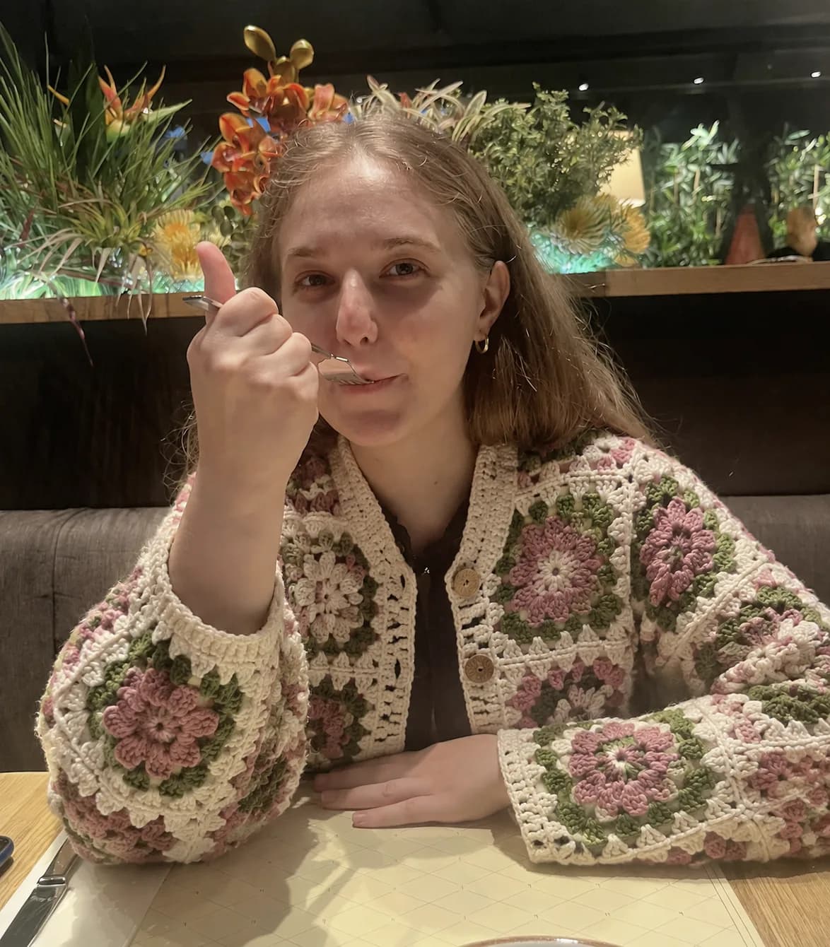 Rose and sage green crochet cardigan in an open garden cafe
